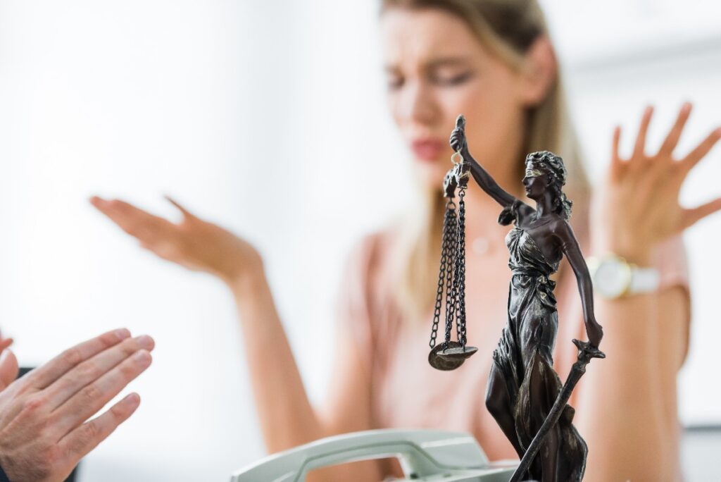 Selective Focus Of Themis Figurine And Lawyer Gesturing With Hands