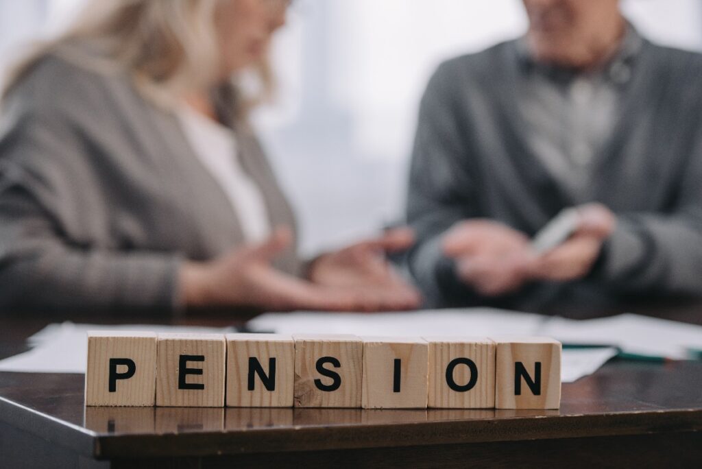 Selective Focus Of Word 'pension' Made Of Wooden Blocks With Senior Couple On Background
